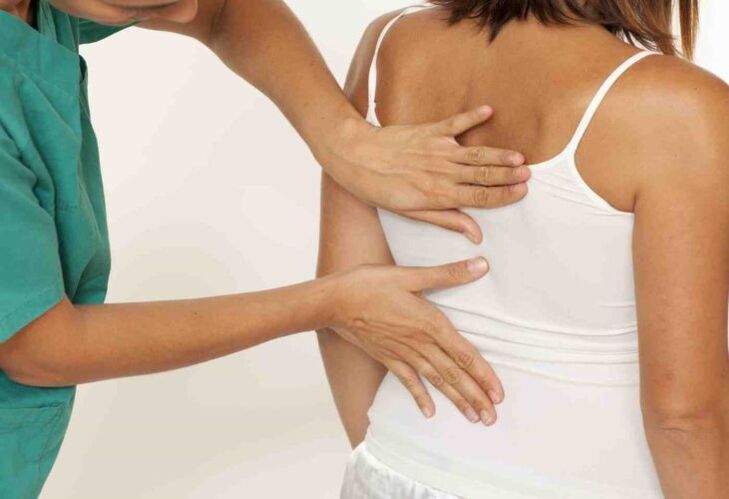 o médico examina as costas con dor nos omóplatos
